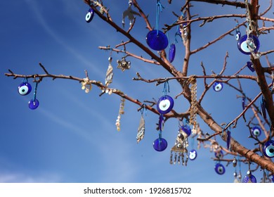 Turkish amulet from the evil eye on a tree against a blue sky