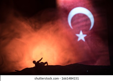 Turkish Army Concept. Silhouette Of Wounded Soldier Against A Turkish Flag. Creative Artwork Decoration. Military Silhouettes Fighting Scene Dark Toned Foggy Background. Selective Focus