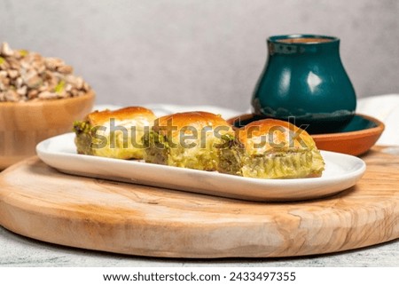 Turkish baklava. Mediterranean cuisine flavours. Pistachio baklava with turkish coffee on rustic table, ramadan or holiday desserts concept