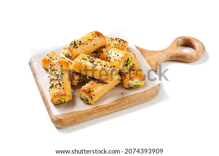 Turkish borek rolls with spinach and cheese. A traditional Turkish pastry rulo borek with black and white sesame seeds. Isolated on white background.