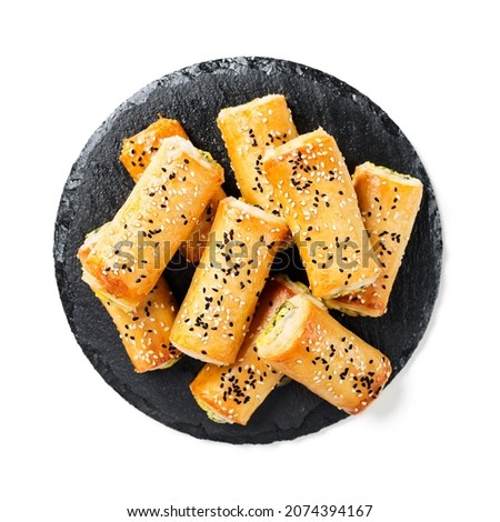 Turkish borek rolls with spinach and cheese. A traditional Turkish pastry rulo borek with black and white sesame seeds. Isolated on white background. top view