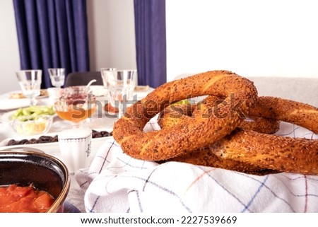 Turkish breakfast concept with bagel called simit in Turkish.  Beautiful table presentation. Ready for guests. Delicious repast, brunch, classic morning feast. Empty water glasses. Copy space.