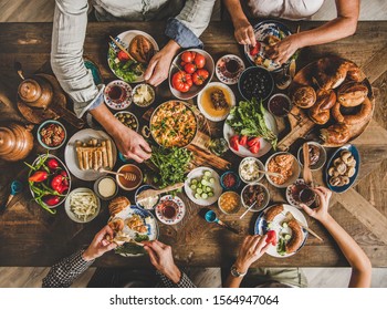 Turkish Breakfast. Flat-lay Of Turkish Family Eating Traditional Pastries, Vegetables, Greens, Cheeses, Fried Eggs, Jams And Tea In Copper Pot And Tulip Glasses Over Rustic Wooden Background, Top View