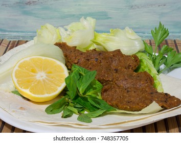 turkish cigkofte and lemon on lettuce, lettuce, parsley, mint