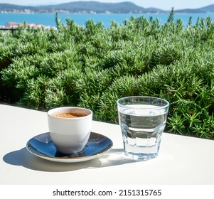 Turkish Coffee And A Glass Of Water On A White Table On The Terrace In A Cafe