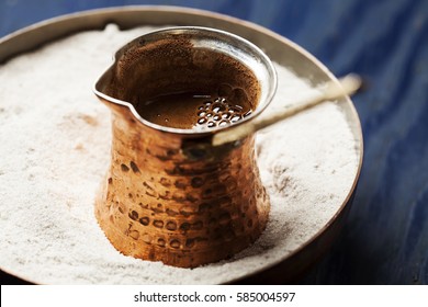 Turkish coffee made in cezve (traditional coffee pot) on sand
