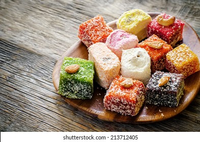 Turkish delight on a dark wood background. toning. selective focus on the white delight. - Shutterstock ID 213712405