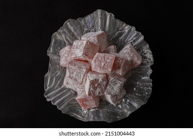 Turkish delight, rose flavored Turkish delight in a glass plate. Dark background. top view.