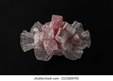 Turkish delight, rose flavored Turkish delight in a glass plate. Dark background.