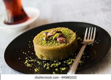 Turkish Dessert Irmik Helvasi / Semolina With Pistachio Powder And Tea.