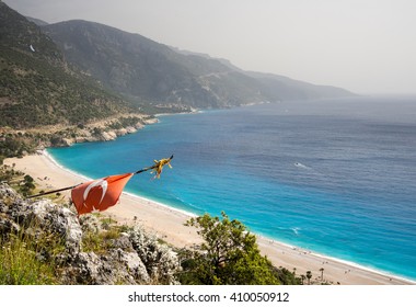 Turkish Flag Over A Beach On A Mediterranean Sea. Oludeniz, Fethiye, Turkey.