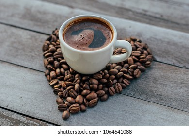 Turkish or Greek Coffee in heart shaped roasted coffee beans on white rustic wooden table from top view. Traditional tasty refreshment greek or turkish coffee from greek or turkish cuisine culture - Powered by Shutterstock