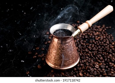Turkish Jezve Coffee Pot with hot coffee at coffee beans background