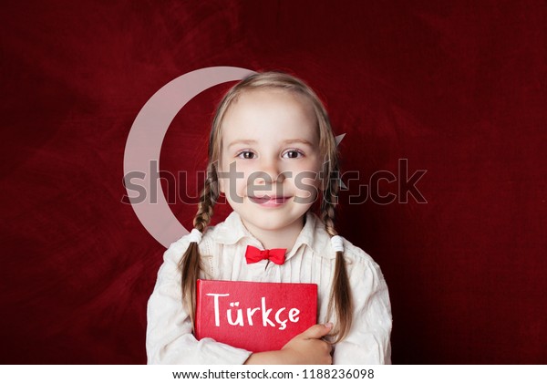 Turkish language\
concept. Cute child girl student on the Turkey flag background.\
Learn turkish language