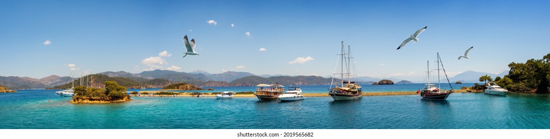 Turkish riviera near the Fethiye coastline resort, wide panorama. Sea vacation on the coast of Aegean Sea in Turkey. View on a beautiful lagoon with sail yachts, motor boats and islands around.
