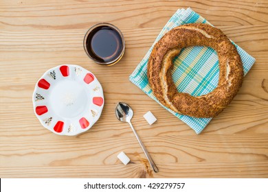 Turkish Simit And Tea On A Blue Plaid Napkin With Sugars On Wooden Surface Top View