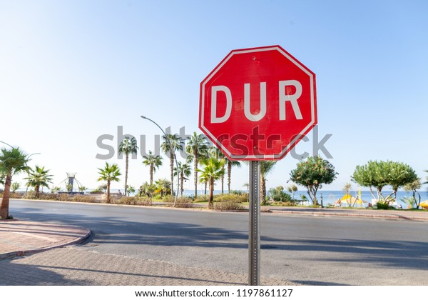 Turkish Stop sign on a street near the beach. DUR\
is the turkish word for\
stop.