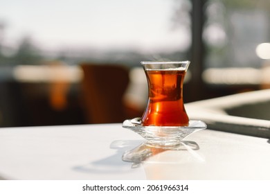 Turkish Tea Served In Tulip-shaped Glass On Rustic Table. Turkish Tea In Traditional Glass Cup. Turkish Traditional Hot Drink