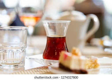 Turkish Tea In Traditional Shape Glass On Table In Restaurant. Close Up Low Angle Shot In Sun Bright Light