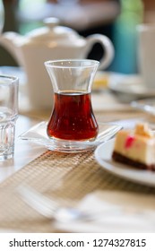 Turkish Tea In Traditional Shape Glass On Table In Restaurant. Close Up Low Angle Shot In Sun Bright Light