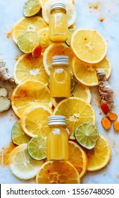 Turmeric Ginger Lemon Shots - perfect as healthy immune system boost in winter - in small glass bottles displayed next to the ingredients.