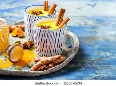 Turmeric golden milk latte with cinnamon sticks and honey. Detox, immune boosting, anti inflammatory healthy cozy drink  - Powered by Shutterstock