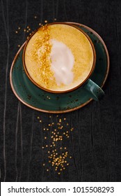 Turmeric latte or golden milk with glitter stars , The drink is made by steaming milk with aromatic turmeric powder and spices