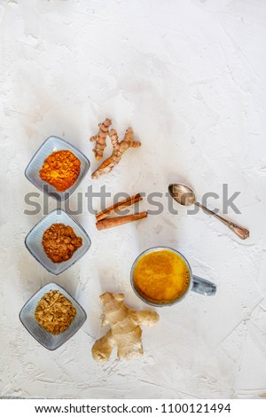 Turmeric latte ingredients. Ground turmeric, curcuma root, cinnamon, ginger, grey ceramic bowls on grey cincrete background. Top view, copy space
 Stock photo © 