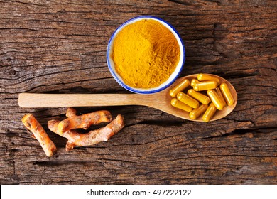 The Turmeric Powder , Capsule And Roots Curcumin On Wooden Plate