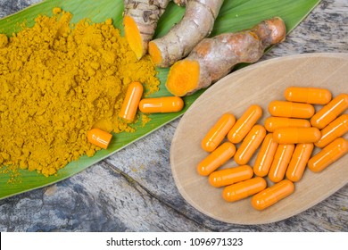 Turmeric Powder ,capsules , Roots And Leaf, Curcumin Herb Medicine On Wooden Table