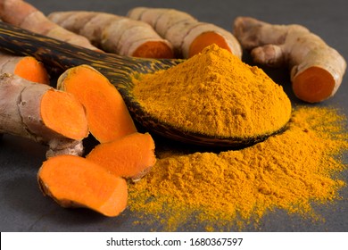 Turmeric Powder And Fresh Turmeric (curcumin) On The Black Background.