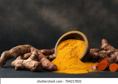 Turmeric powder and fresh turmeric on wooden background.with copy space.