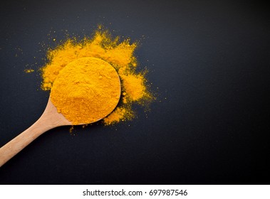 Turmeric powder on black background.