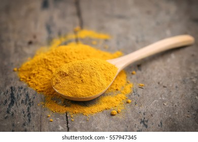 Turmeric powder on wooden background.