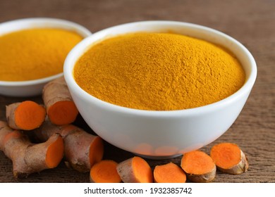 Turmeric Powder In A White Bowl And Fresh Turmeric (curcumin) On Wooden Background,For Cooking And For Herbs.