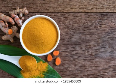 Turmeric Powder In A White Bowl And Fresh Turmeric (curcumin) On Wooden Background, Natural Fabric Dye, Top View, Copy Space.