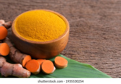 Turmeric Powder In A Wooden Bowl And Fresh Turmeric (curcumin) On Wooden Background, Natural Fabric Dye, Copy Space.