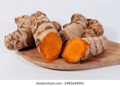 Turmeric root with slice on a cutting board and white background - Powered by Shutterstock