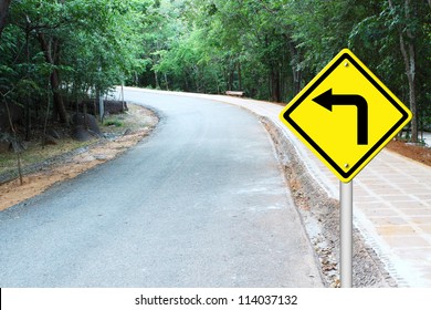 Turn Left Warning Sign On A Curve Road