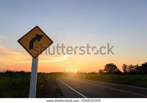 Turn right traffic sign.\
Direction sign- right turn warning on sunset background with blank\
for text
