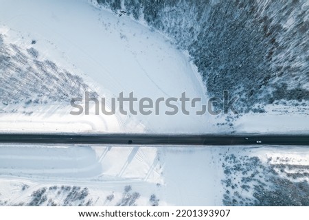 turn of the river ice and snow on the river, bridge over the river aerial view. winter landscape from above. road in the forest across the river