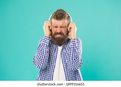 Turn The Sound Down. Unhappy Hipster Listening Ebook. Bearded Man With Loud Sound In Earphones. Caucasian Guy With Beard And Mustache Listen Song. Mature Male Singer. Concept Of Music.