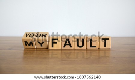 Turned a cube and changed the expression 'my fault' to 'your fault'. Beautiful wooden table, white background, copy space. Business concept.
