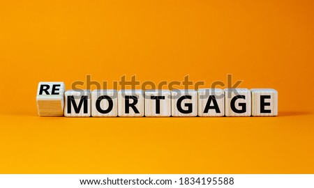 Turned a cube and changed the word 'remortgage' to 'mortgage' or vice versa. Beautiful orange background, copy space. Business concept.