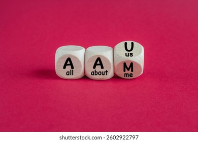 Turned a cube and changes the expression AAM (all about me) to AAU (all about us). Beautiful red background, copy space.