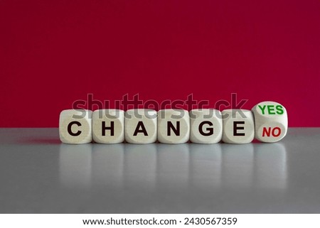 Turned a cube and changes the green words change no to change yes. Beautiful grey table, pink background. Copy space.
