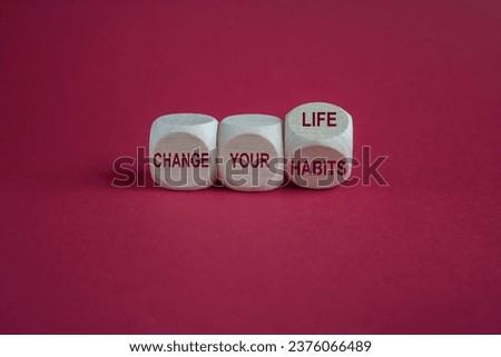 Turned a cube and changes the slogan change your habits to change your life. Beautiful red background. Copy space. Business and change concept.