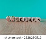 Turned dice and changes the German expression zunehmen (gain weight) to abnehmen (lose weight). Beautiful blue background, wooden table copy space.