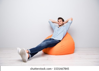 Turned full length body size photo of cheerful confident relaxing man sitting in chair thinking guessing smiling toothily having rest fun isolated over grey color background - Powered by Shutterstock