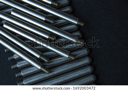 The turned parts on the production table in a row against a dark background. The manufacture of axles in the factory.